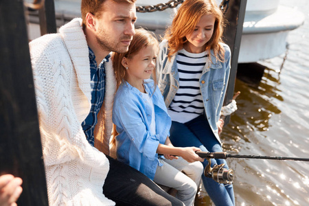 幸福的家庭与女儿在池塘捕鱼秋季