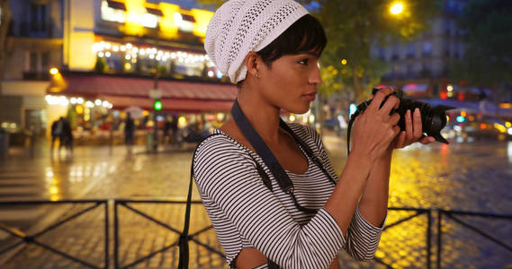 用数码相机拍摄城市夜生活的创意年轻黑人妇女