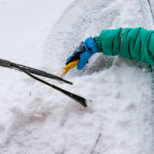 用刷子交通冬季天气人和车辆概念清洗汽车上的雪