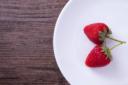两个红草莓在白盘子里