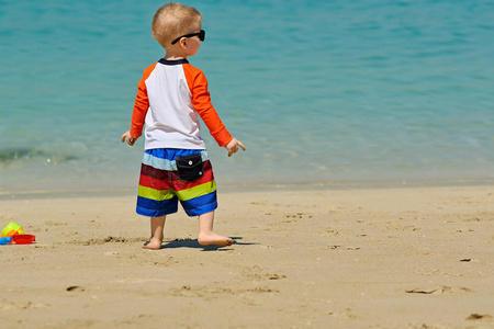 两岁的小孩在沙滩上玩沙滩玩具