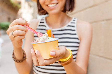 在城里, 旅行妇女正在尝试戴草帽吃冰淇淋