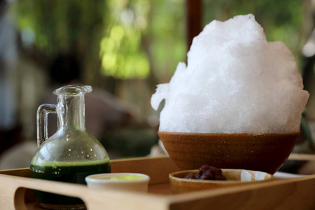 美味的日本甜剃光冰绿茶在木桌上在日本咖啡馆