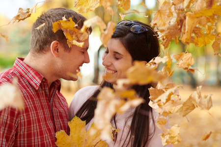 夫妇是在秋天城市公园。明亮的黄色树