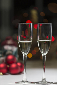 两杯香槟, 在背景中的圣诞节气氛在红色色调, 温暖的家