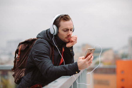 男子在耳机听音乐在城市户外