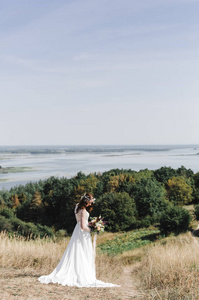 新娘穿着白色连衣裙在山顶上对河漏油事件