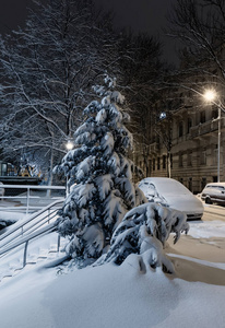 美丽的黄昏黄昏冬季城市景观在乌克兰利沃夫市中心。这辆车覆盖着积雪。