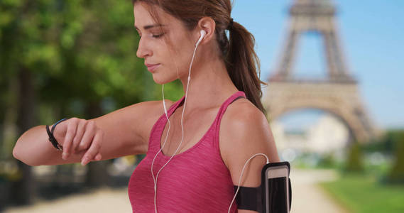 在巴黎埃菲尔铁塔附近, 她在巴黎晨间慢跑的运动白人女性检查手表
