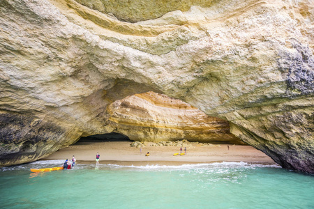 游客在皮划艇享受杰出的美贝纳吉尔海蚀洞穴, 阿尔加维, 葡萄牙
