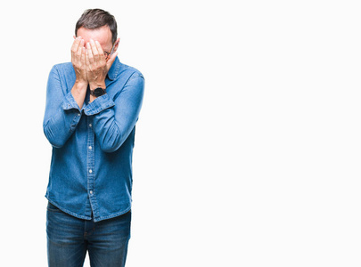 中年老人戴着眼镜, 在与世隔绝的背景下, 带着悲伤的表情, 用手捂着脸