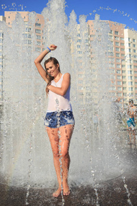 有吸引力的女孩沐浴在城市喷泉
