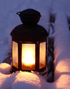 雪地长凳上的蜡烛灯