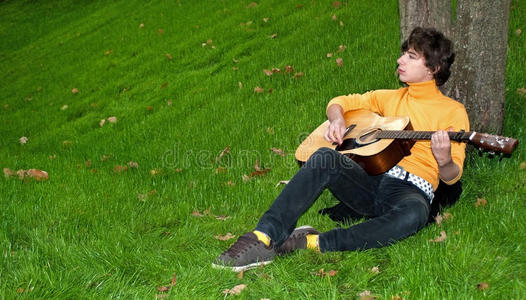 草地上弹吉他的少年