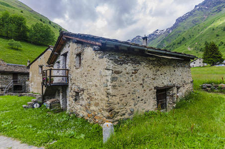阿尔卑斯山背景下一个农民村庄的阿尔卑斯石屋