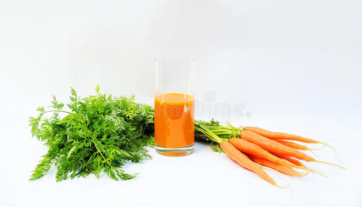 一束胡萝卜和一杯胡萝卜汁图片