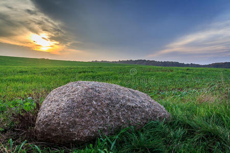 日落时草地上的石头照片
