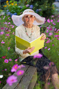 优雅的老太太在花园里看书