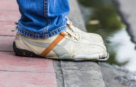 破鞋白色背景上的破鞋的特写站在木地板上的亚洲男人的赤脚.破鞋.