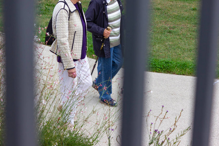 在德国城市公园的高级夫妇与拐杖在秋天下午