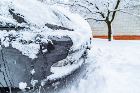 汽车在冰雪停在院子里。冬季时间