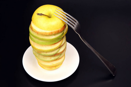 苹果用叉子在白色茶托上切成碎片