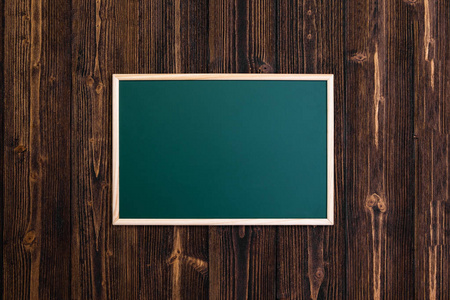 木制桌上有木架的空绿色黑板, 带有复制空间的顶部视图, 用于添加文本和邮件