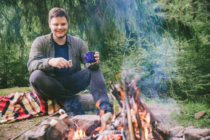 男人在外面吃饼干和喝茶.露营