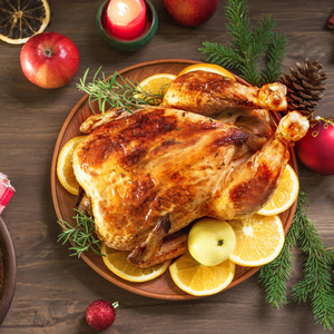 烤圣诞鸡或火鸡作为圣诞晚餐。节日装饰的木桌圣诞晚餐与烤鸡