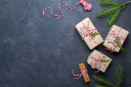 包装圣诞礼物。圣诞礼品盒和装饰品, 黑桌子上的松树树枝。现在装饰与自然的部分顶部视图与复制空间