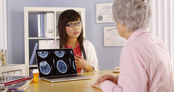 亚洲医生向老年患者解释脑部扫描