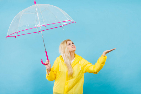 女人穿着雨衣打着伞检查天气