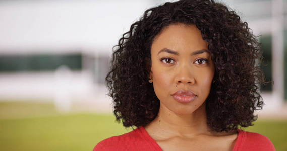 黑色千禧年女孩与严肃的表情看着户外相机照片