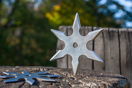 日本飞镖飞镖 (投掷的星), 传统日本忍者冷的武器陷在木背景照片