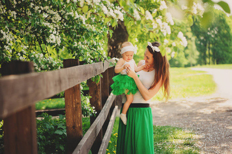 春天的母亲和婴儿的女儿玩户外在相配的衣服长裙子和衬衫的画像。快乐家庭神清气爽度假