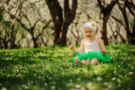 可爱的开心宝贝女孩走在春天的花园户外。快乐的童年