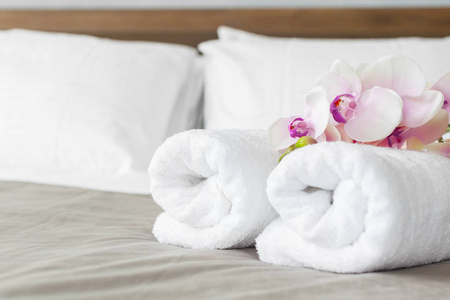 在酒店房间的床上关闭毛巾和鲜花