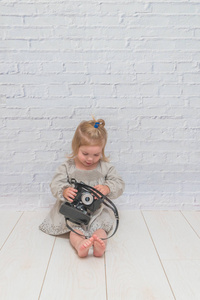 女孩, 孩子与老式照相机在白色砖墙背景