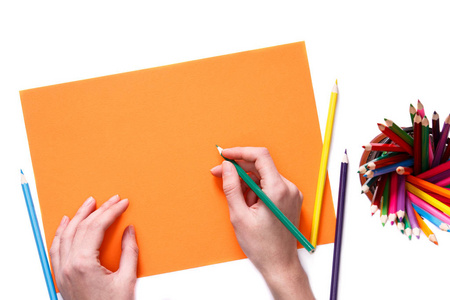 人类的手，用铅笔在孤立的白色背景上的橙色纸上画的东西