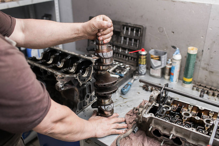 在汽车发动机维护维修工作的机械修理工照片