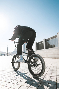 穿着休闲服装的年轻人在阳光明媚的夏日骑着 bmx。bmx 骑手回来了。bmx 概念