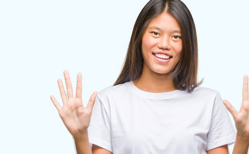 年轻的亚洲妇女在孤立的背景显示和指向手指数十, 而微笑着自信和快乐