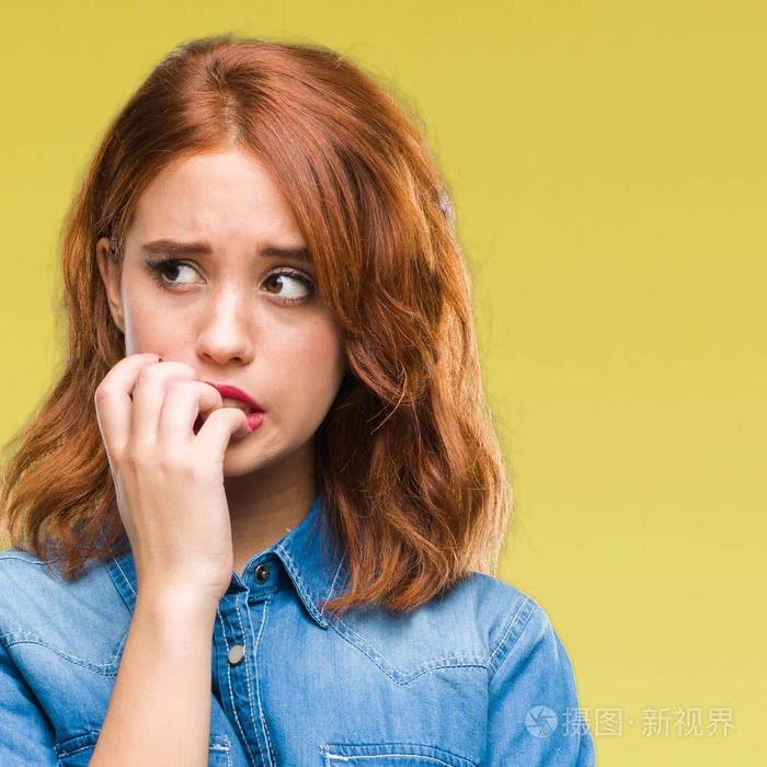 年轻美丽的女人在孤立的背景下, 神情紧张, 手上叼着钉子.焦虑问题