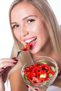 年轻漂亮的女人吃蔬菜沙拉。健康的饮食。要在形状中