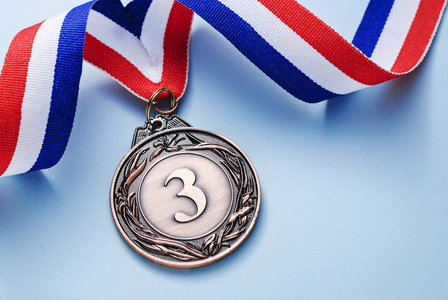 铜牌3地方与丝带在浅蓝色背景, 胜利或成功的概念