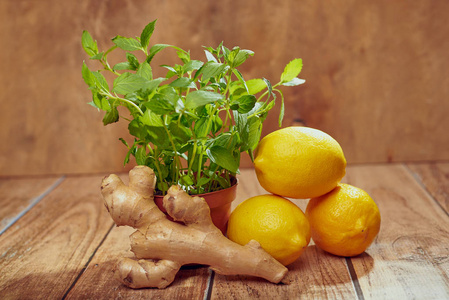 在木桌上的锅里用生姜,柠檬和薄荷来关闭照片
