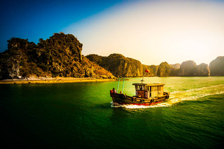 日落在下龙湾越南与旅游船在前景