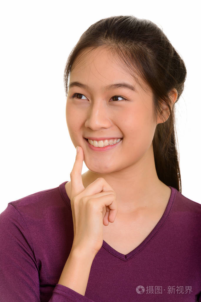 年轻快乐亚洲青少年女孩微笑着,思考