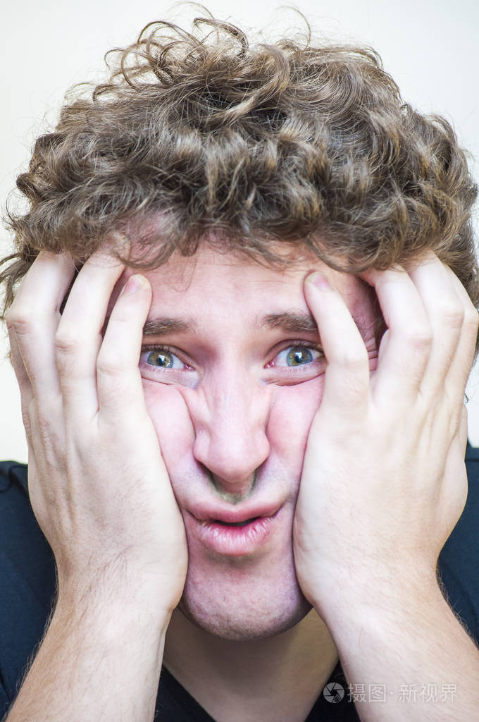 年轻震惊集中的人的肖像, 覆盖他的沮丧的脸, 两只手在白色背景