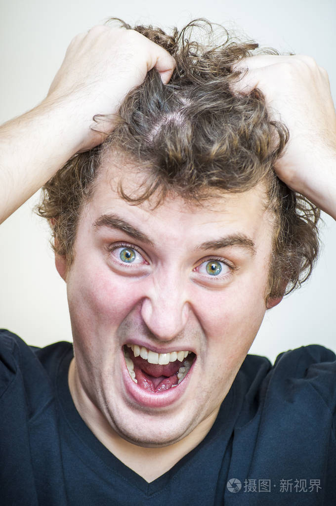 年轻的愤怒尖叫卷曲的人的肖像眼泪他的头发在白色背景